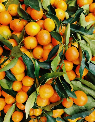 pexels photo 2294477 2294477 A vibrant pile of fresh tangerines with green leaves, showcasing natural freshness and vivid colors.